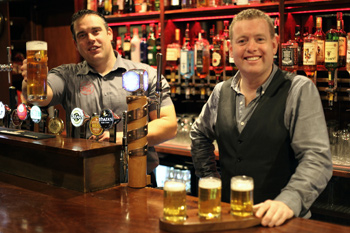 From left: With the emphasis firmly on ‘kitchen’, Bar Manager Declan Kelly toasts the Purty Kitchen’s new owner Ashley Sheridan, who, together with partner John McCluskey also owns the Step Inn in Stepaside.