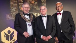 Louis Hennessy on stage with National President Mike Mitchelson and awards host, Sir Trevor McDonald