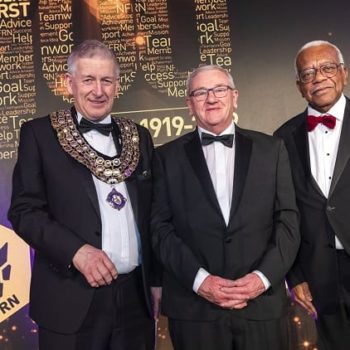 Louis Hennessy on stage with National President Mike Mitchelson and awards host, Sir Trevor McDonald